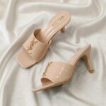 Ruby Mule Heel – Beige glossy mule heel with gold-tone detailing and square-toe design.